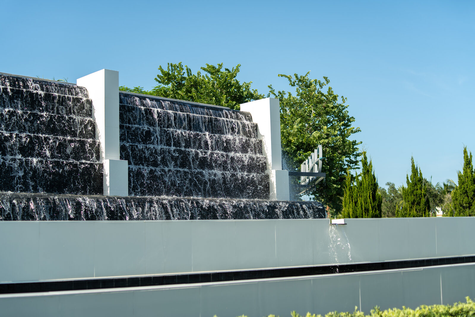 Restored commercial water wall and spillway at a gated community entrance in Parkland, Florida