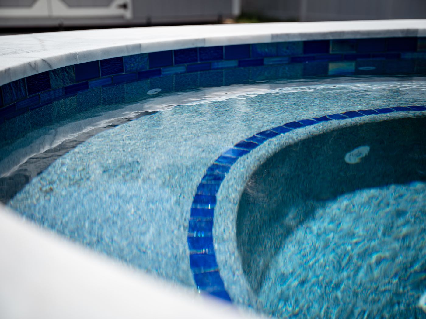 Close-up of a PebbleSheen Blue Surf finish with cobalt glass waterline tile